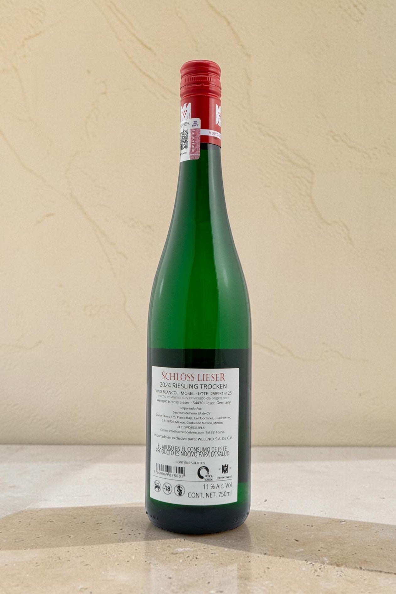 Botella de vino blanco Wellnex Schloss Lieser Riesling Trocken 2024 con etiqueta trasera informativa y tapón rojo