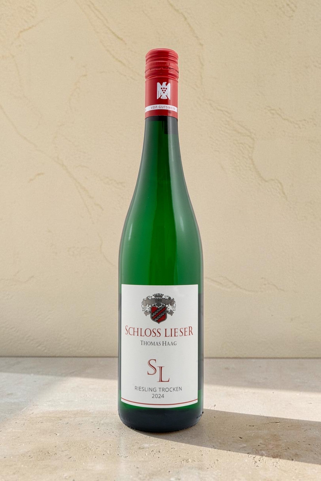 Botella de vino blanco Wellnex Schloss Lieser Riesling Trocken con etiqueta elegante y tapón de rosca rojo