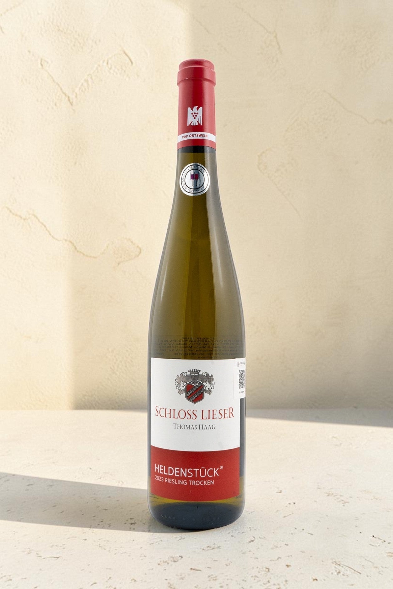 Botella de vino blanco Wellnex Schloss Lieser Heldenstück Riesling Trocken con etiqueta elegante sobre fondo neutro