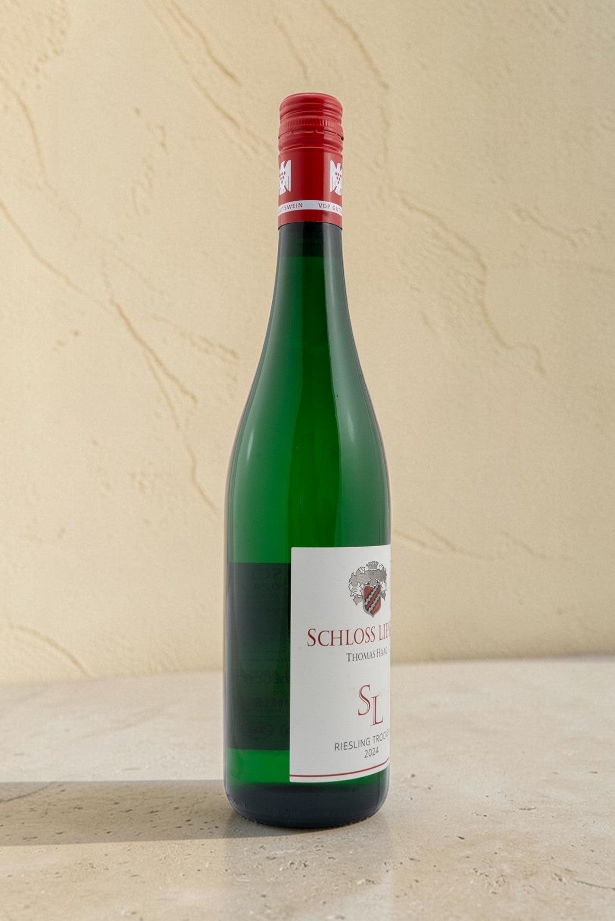 Botella de vino blanco Wellnex Schloss Lieser Riesling Trocken con etiqueta elegante sobre fondo neutro