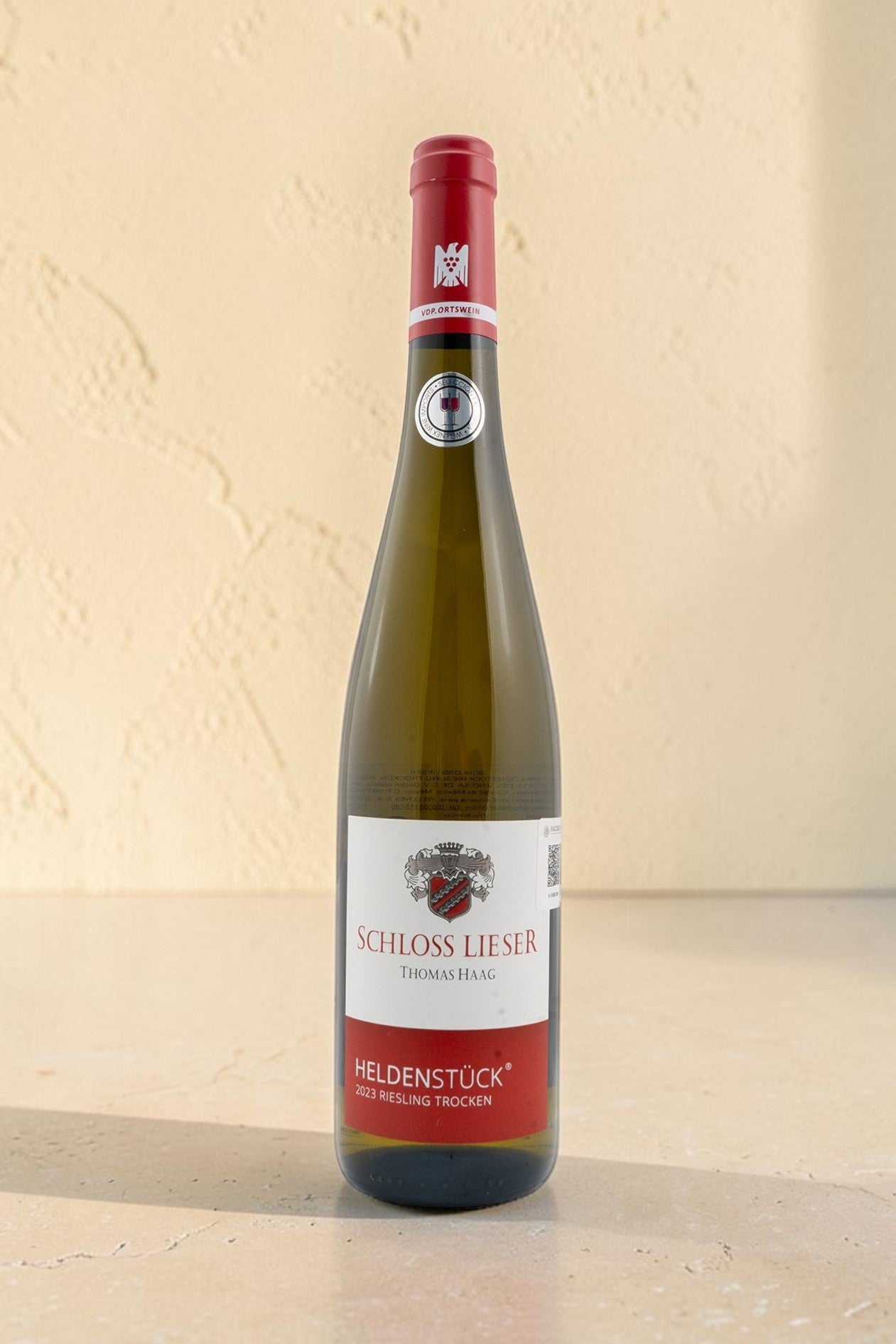 Botella de vino blanco Schloss Lieser Heldenstück Riesling Trocken de Wellnex con etiqueta elegante y sello VDP