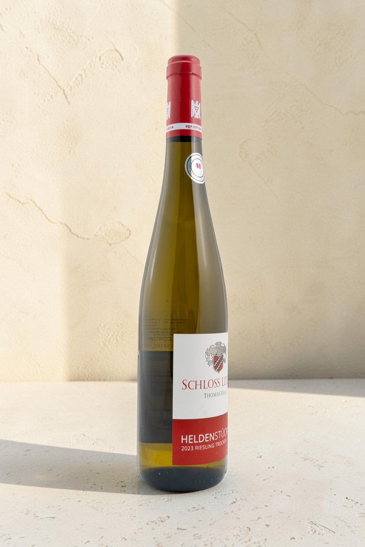Botella de vino blanco Wellnex Schloss Lieser Heldenstück Riesling Trocken 2023 con etiqueta elegante y sello VDP