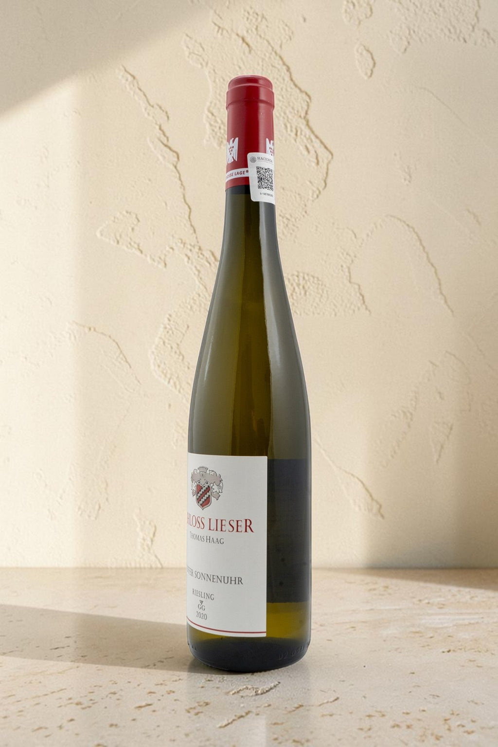 Botella de vino blanco Wellnex Schloss Lieser Juffer Sonnenuhr Riesling GG con etiqueta elegante sobre fondo neutro