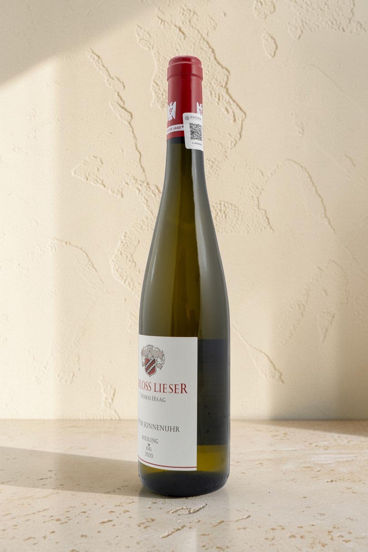 Botella de vino blanco Wellnex Schloss Lieser Juffer Sonnenuhr Riesling GG con etiqueta elegante sobre fondo neutro