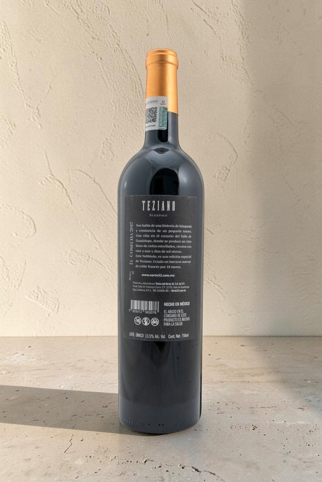 Botella de vino tinto Wellnex Teziano Nebiolo mostrando la etiqueta trasera con información detallada y sello fiscal