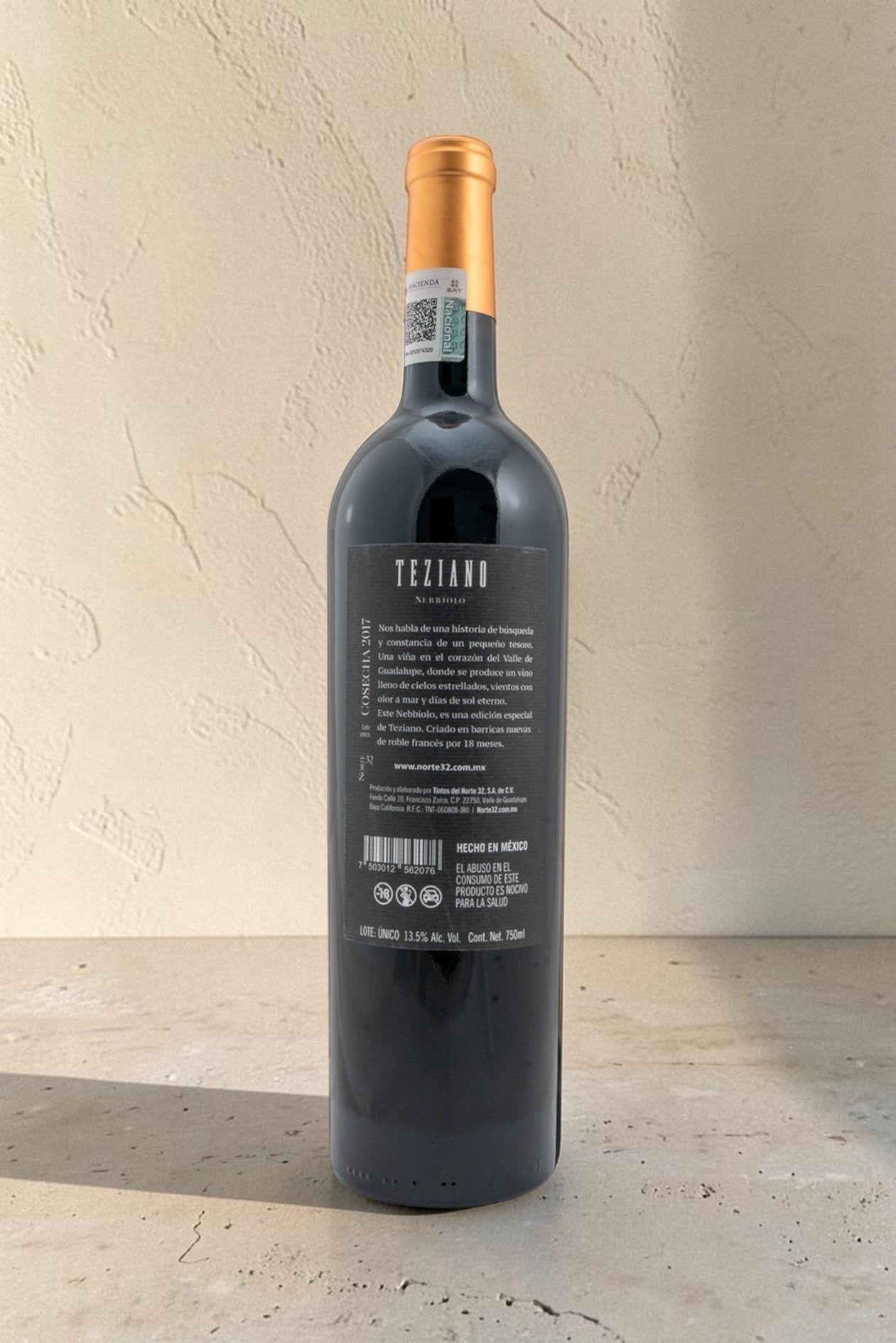 Botella de vino tinto Wellnex Teziano Nebiolo mostrando la etiqueta trasera con información detallada y sello fiscal