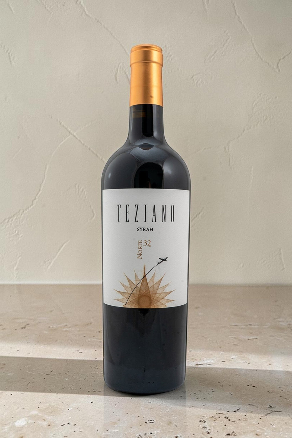 Botella de vino tinto Wellnex Teziano Syrah con etiqueta blanca y diseño de avión sobre fondo neutro