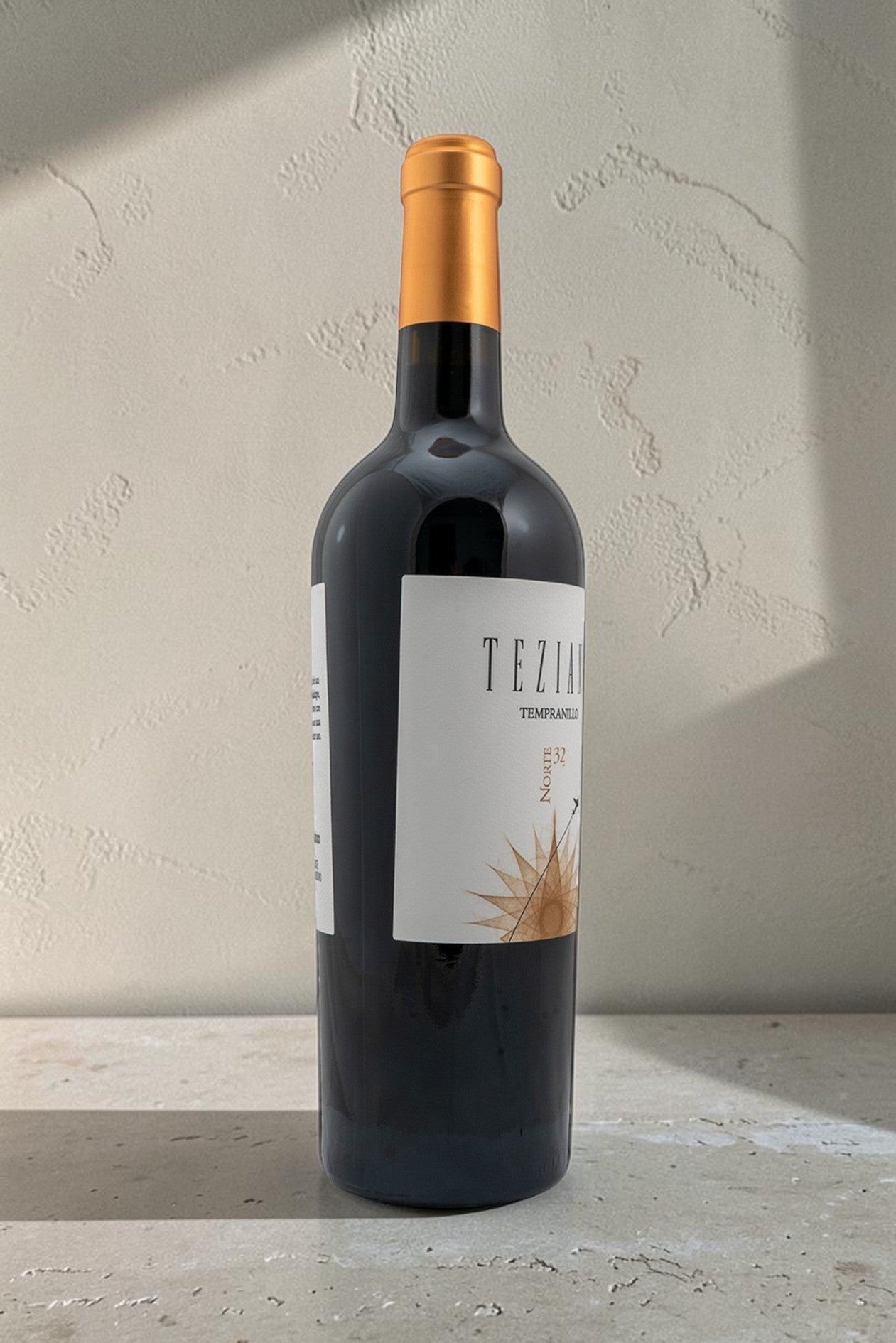 Botella de vino tinto Wellnex Teziano Tempranillo con etiqueta blanca y cápsula dorada sobre fondo neutro