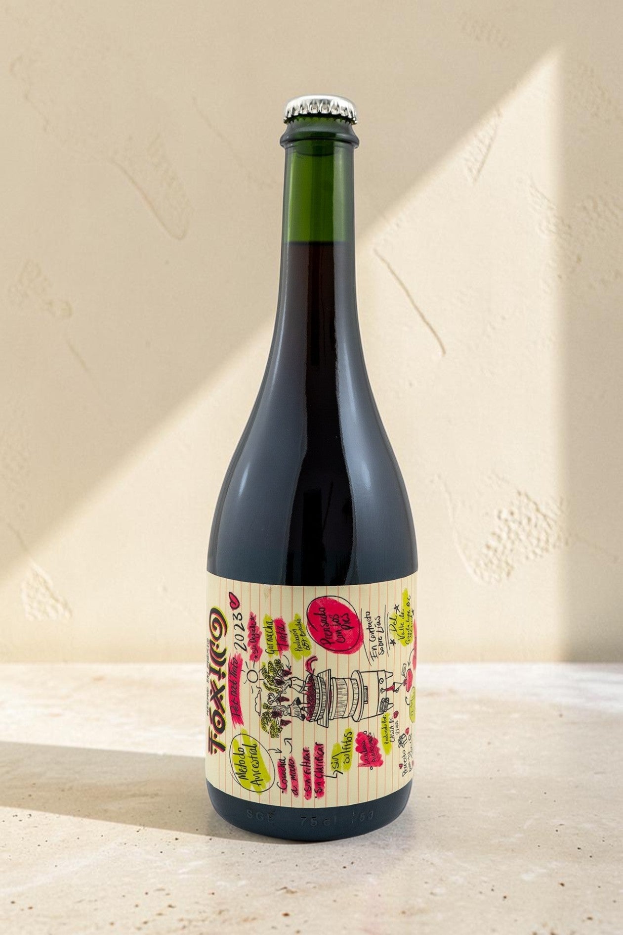 Botella de vino tinto Wellnex Toxico con etiqueta ilustrada estilo cuaderno sobre fondo neutro iluminado