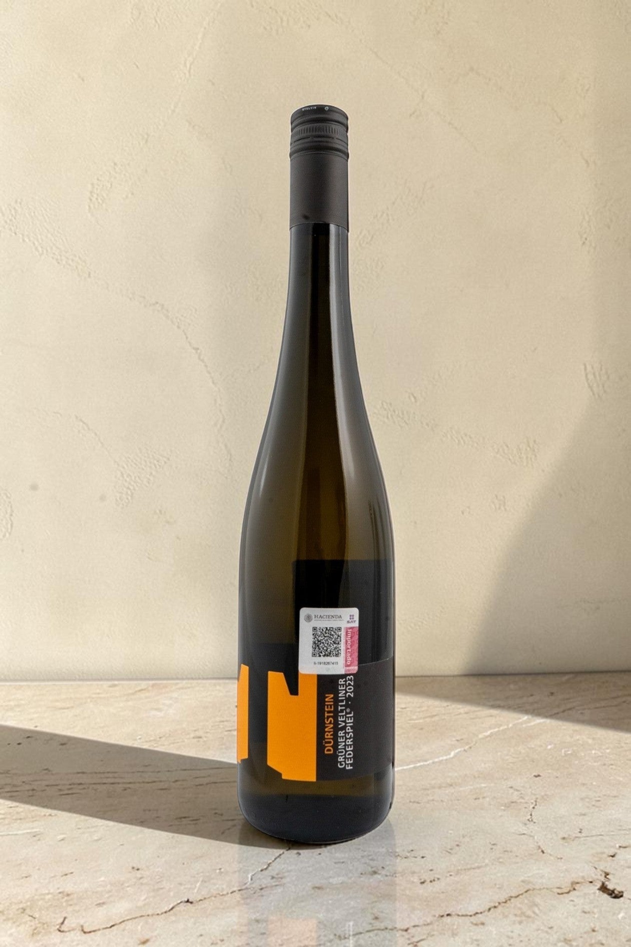 Botella de vino blanco Wellnex Weingut Tegernseerhof Gruner Veltliner Federspiel con etiqueta moderna y minimalista