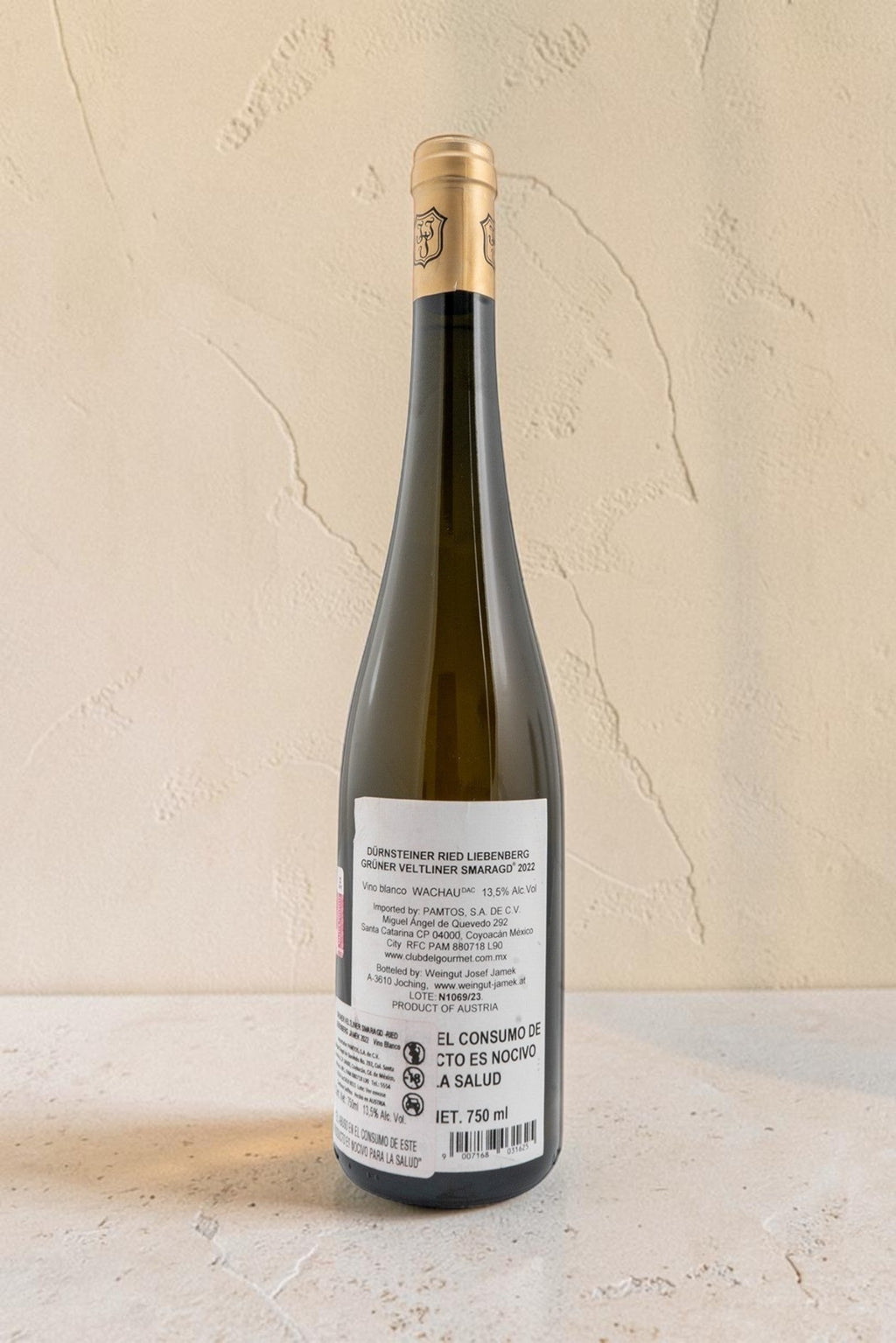 Botella de vino blanco Wellnex Weingut Jamek Gruner Veltliner Smaragd con etiqueta informativa sobre fondo neutro