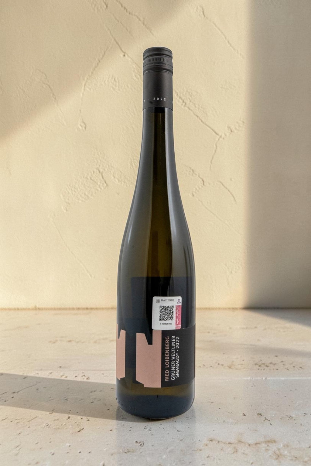 Botella de vino blanco Wellnex Ried Loibenberg Gruner Veltliner Smaragd 2022 con etiqueta moderna y tapón de rosca