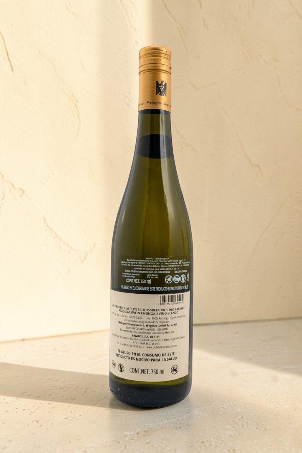 Botella de vino blanco Wellnex Weingut Wegeler Riesling Kabinett con etiqueta trasera detallada sobre fondo texturizado
