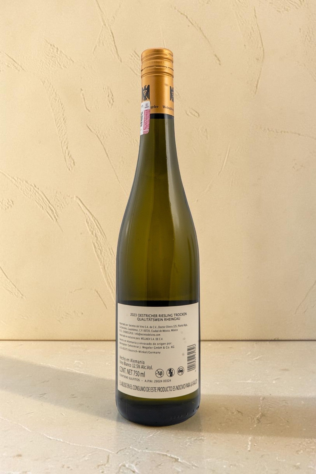 Botella de vino blanco Wellnex Weingut Wegeler Riesling Trocken con etiqueta informativa sobre fondo neutro