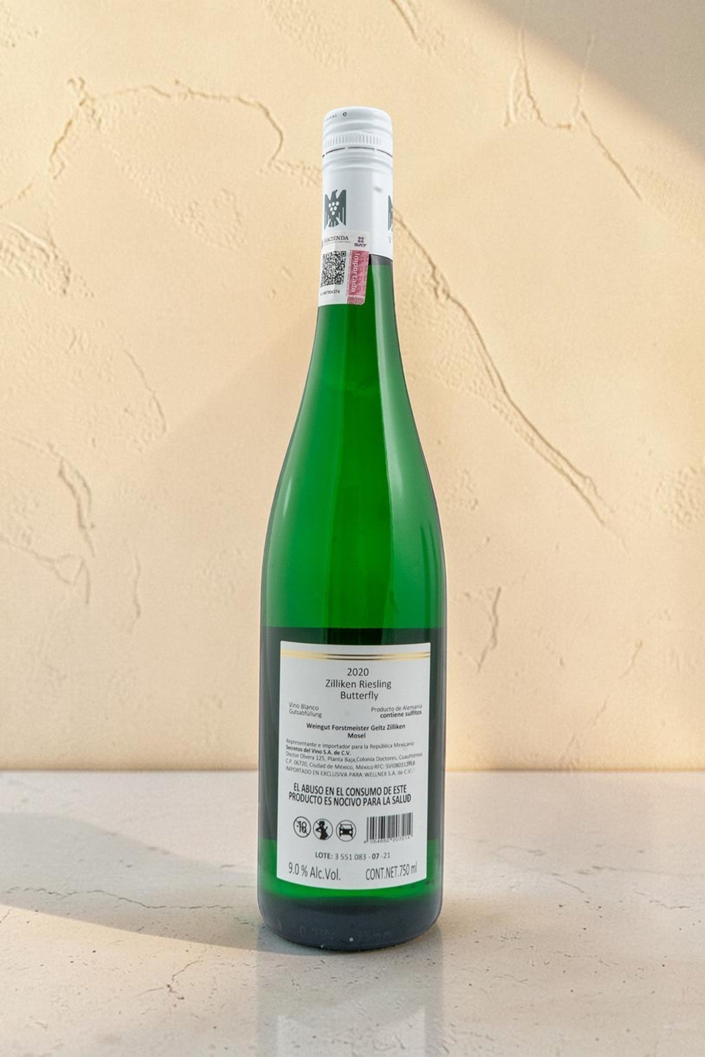 Botella de vino blanco Wellnex Weingut Zilliken Butterfly 2020 con etiqueta trasera informativa sobre fondo neutro