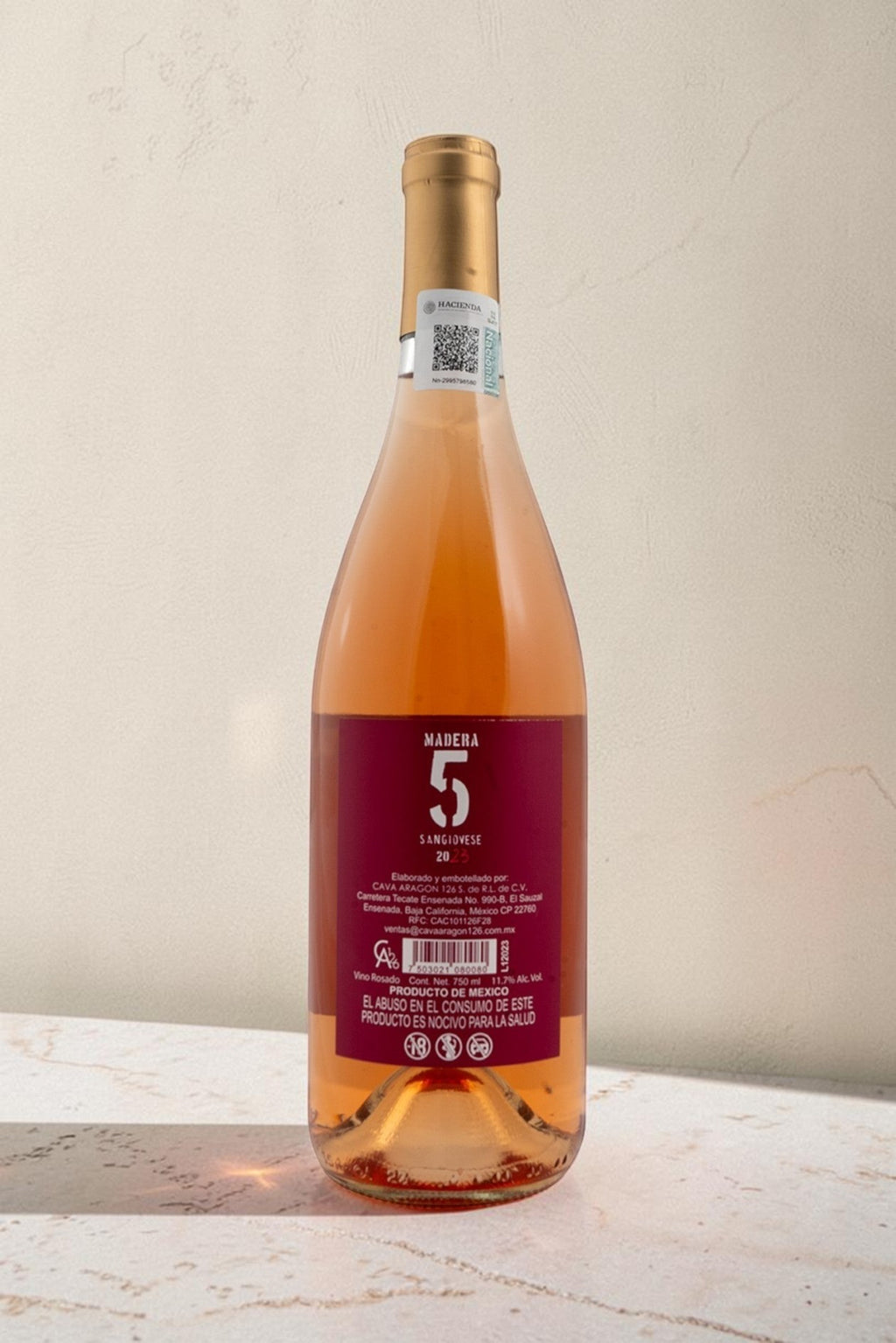 Botella de vino rosado Wellnex Madera 5 Sangiovese con etiqueta trasera informativa sobre fondo neutro.