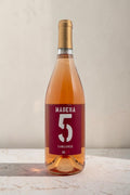 Botella de vino rosado Wellnex Madera 5 Sangiovese 2023 con tono salmón brillante y etiqueta roja