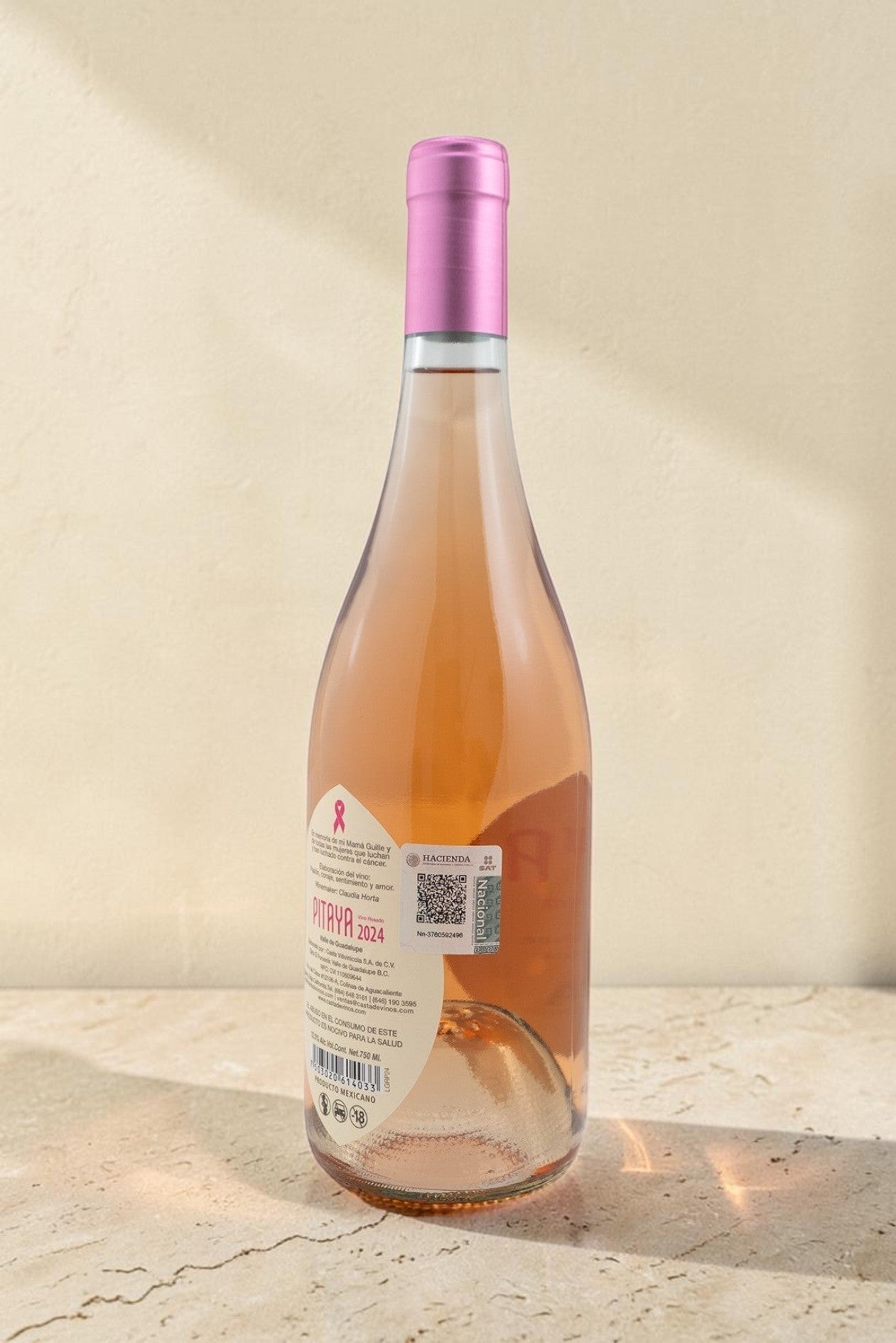 Botella de vino rosado Pitaya de Wellnex con tono salmón pálido y cápsula rosa sobre superficie clara