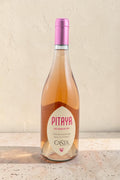 Botella de vino rosado Pitaya de Wellnex con tono salmón pálido y etiqueta elegante sobre superficie de piedra