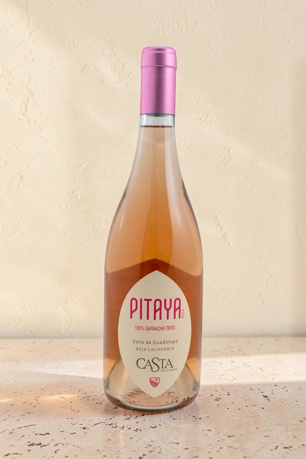 Botella de vino rosado Pitaya de Wellnex, color salmón pálido con etiqueta elegante sobre superficie clara.