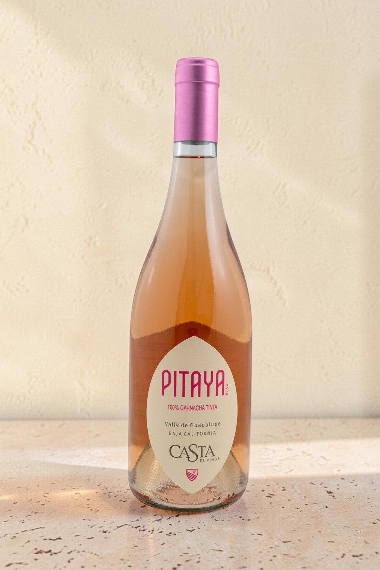 Botella de vino rosado Pitaya de Wellnex, color salmón pálido con etiqueta elegante sobre superficie clara.
