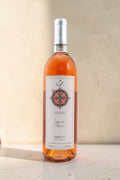 Botella de vino rosado Wellnex Rosa de Los Vientos con etiqueta de brújula sobre fondo neutro
