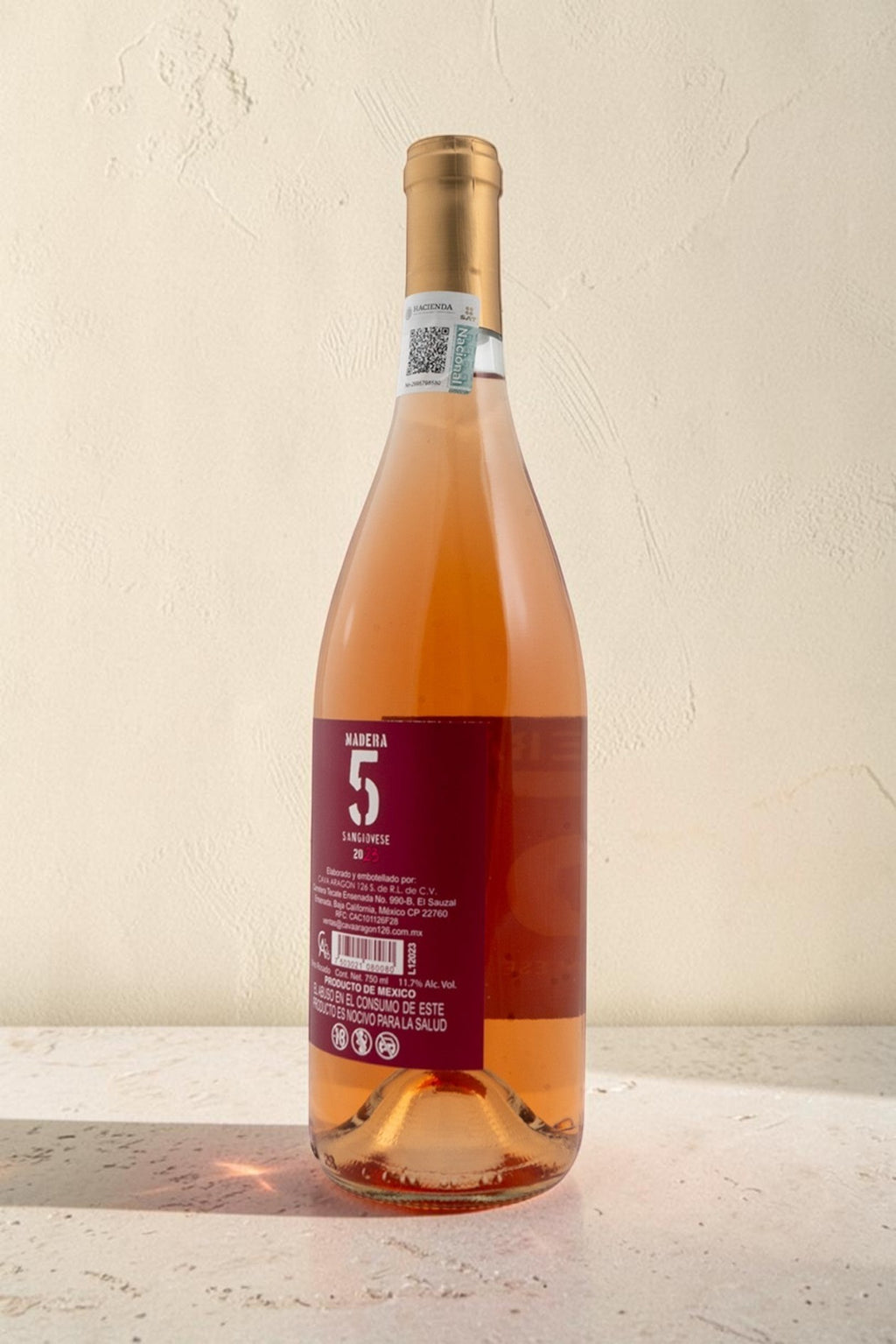 Botella de vino rosado Wellnex con tono salmón brillante, etiqueta con el número 5 y detalles de la cosecha 2023.