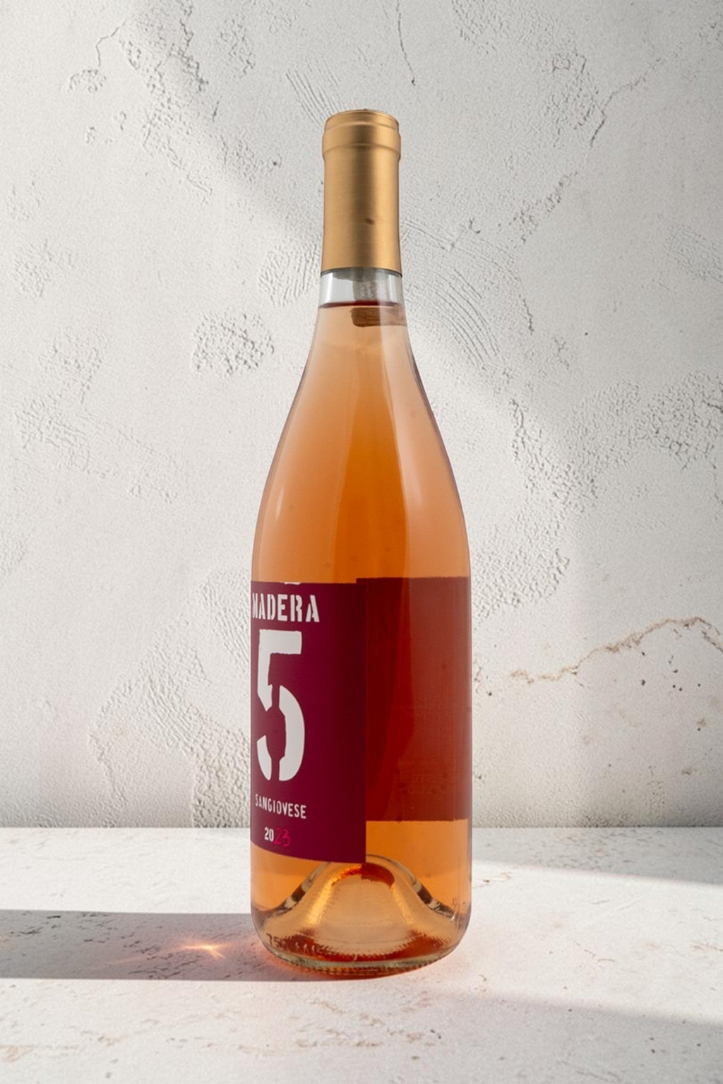 Botella de vino rosado Wellnex Rosado-Saviovese color salmón brillante con etiqueta roja y cápsula dorada