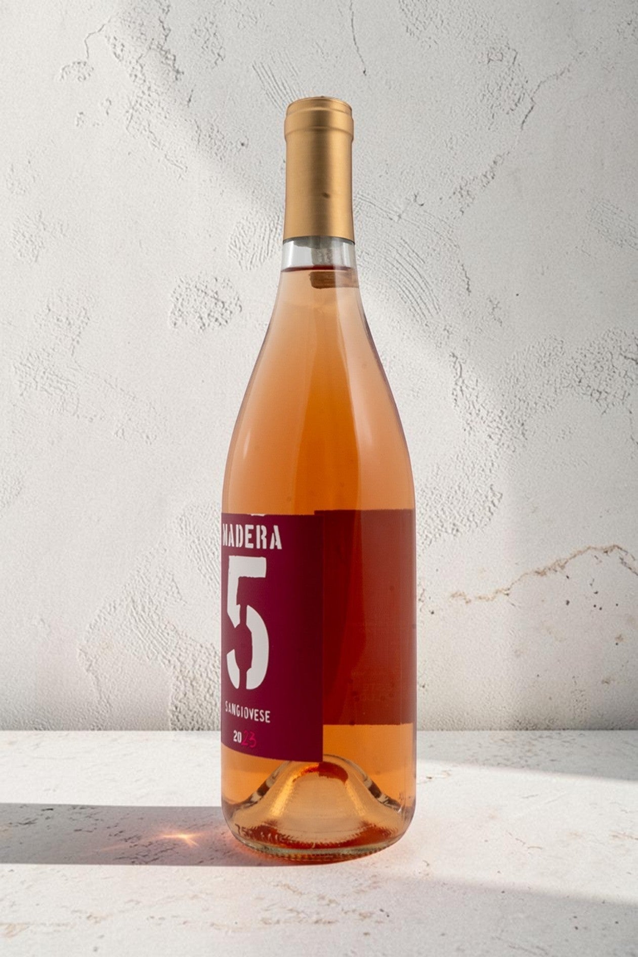 Botella de vino rosado Wellnex Rosado-Saviovese color salmón brillante con etiqueta roja y cápsula dorada