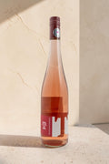 Botella de vino rosado Wellnex Weingut Tegernseerhof VR Federspiel con etiqueta roja sobre superficie clara
