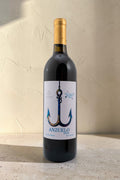 Botella de vino tinto Anzuelo de Wellnex con etiqueta ilustrada de un ancla sobre fondo de pared texturizada