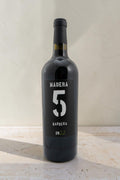 Botella de vino tinto Wellnex Barbera 2022 con etiqueta negra, diseño minimalista y color rojo rubí intenso.