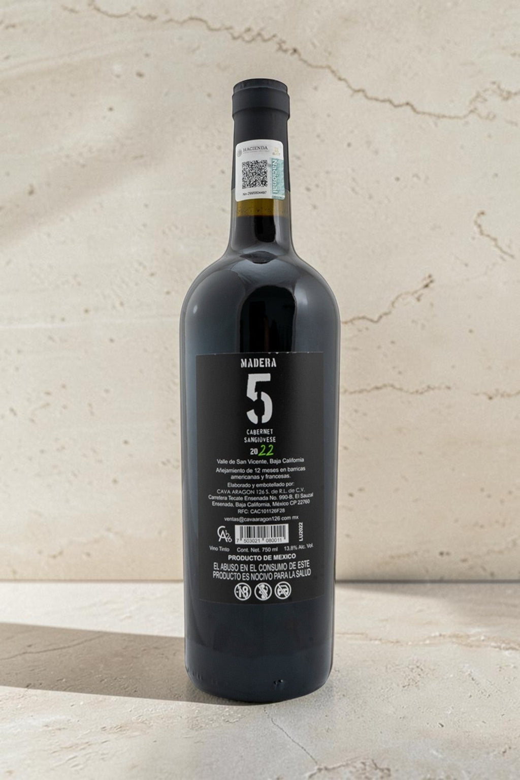 Botella de vino tinto Wellnex Cabernet Sangiovese 2022 con etiqueta negra informativa sobre fondo neutro