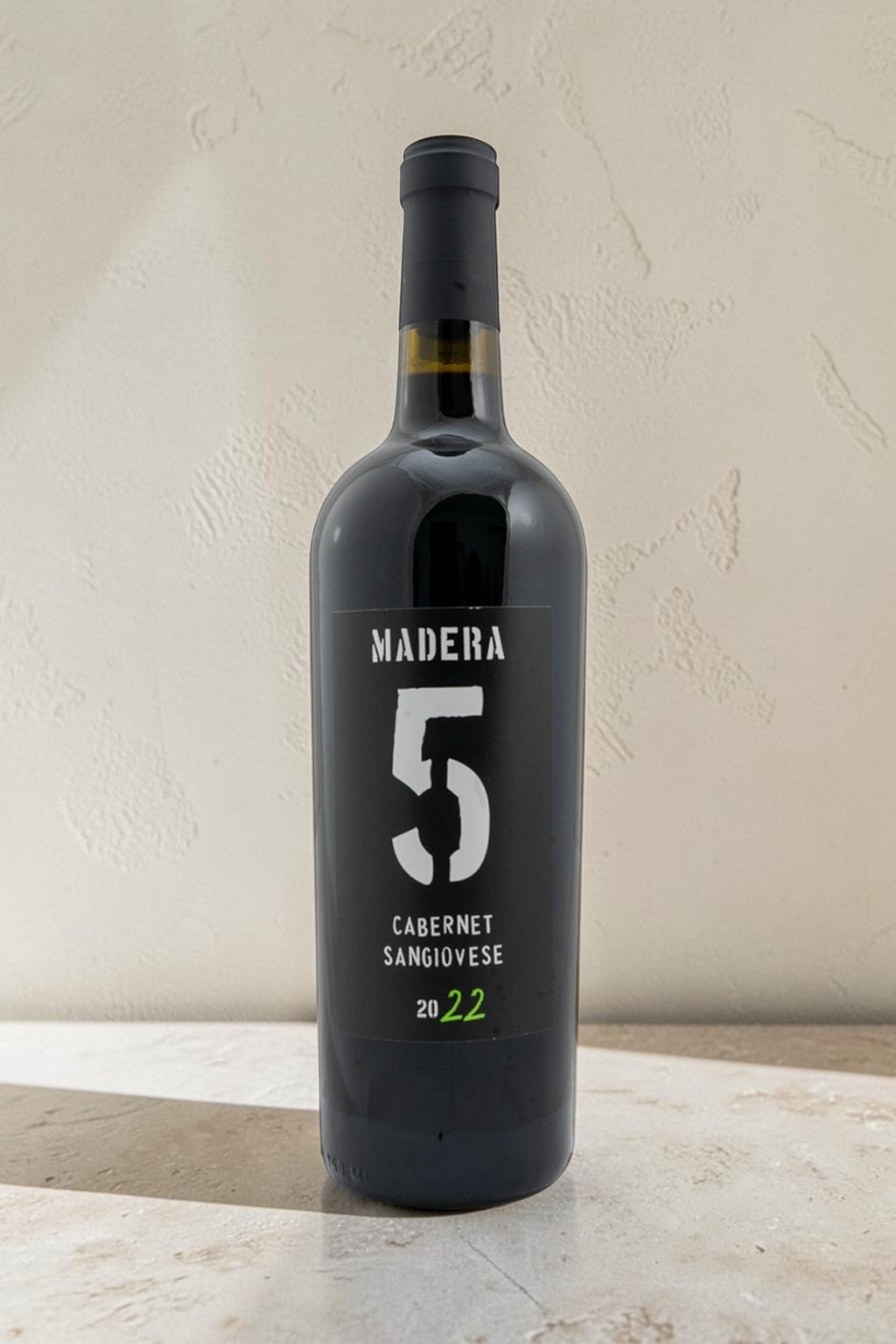 Botella de vino tinto Wellnex Cabernet Sangiovese 2022 con etiqueta negra y número 5 blanco sobre fondo neutro