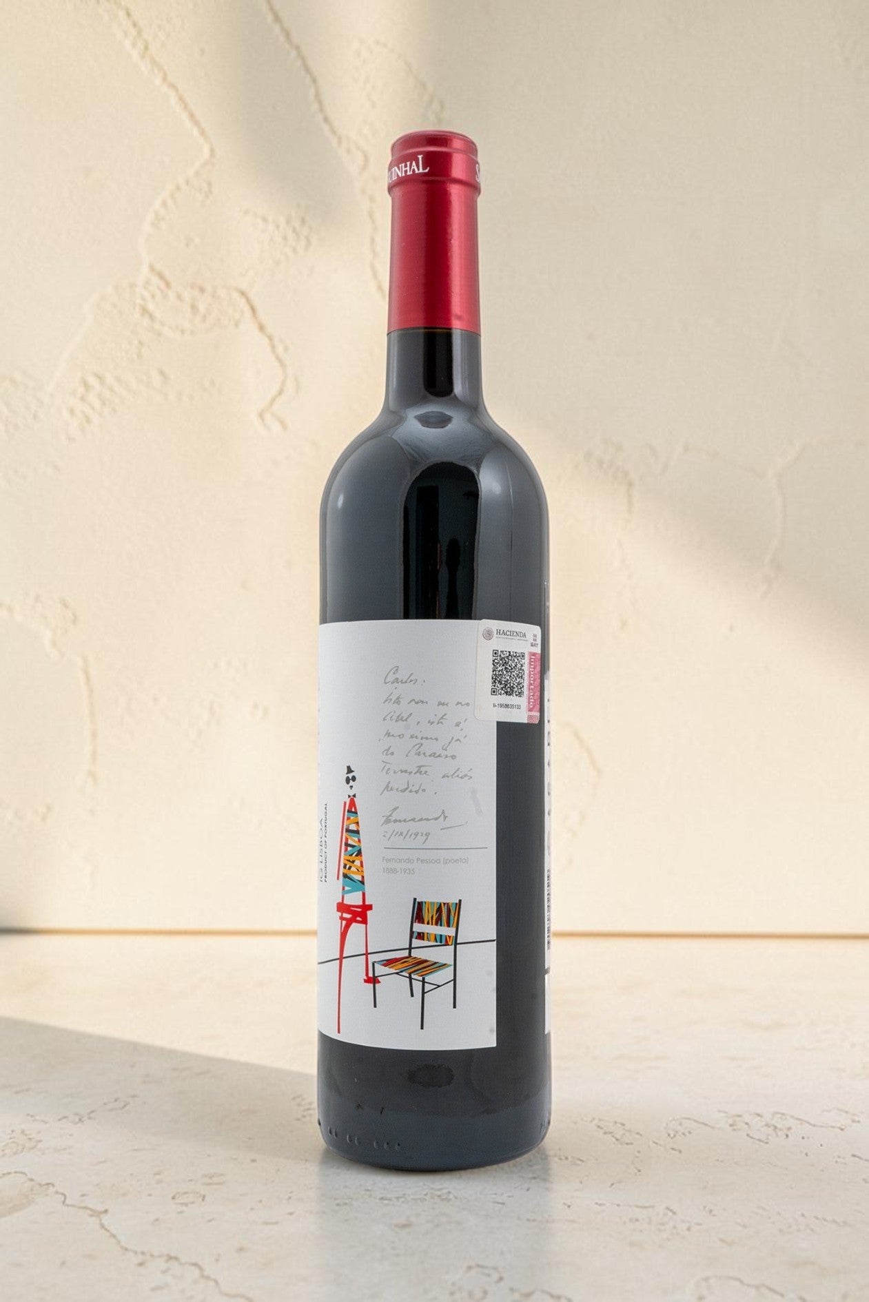 Botella de vino tinto Wellnex Casabel con etiqueta artística ilustrada y cápsula roja sobre fondo neutro