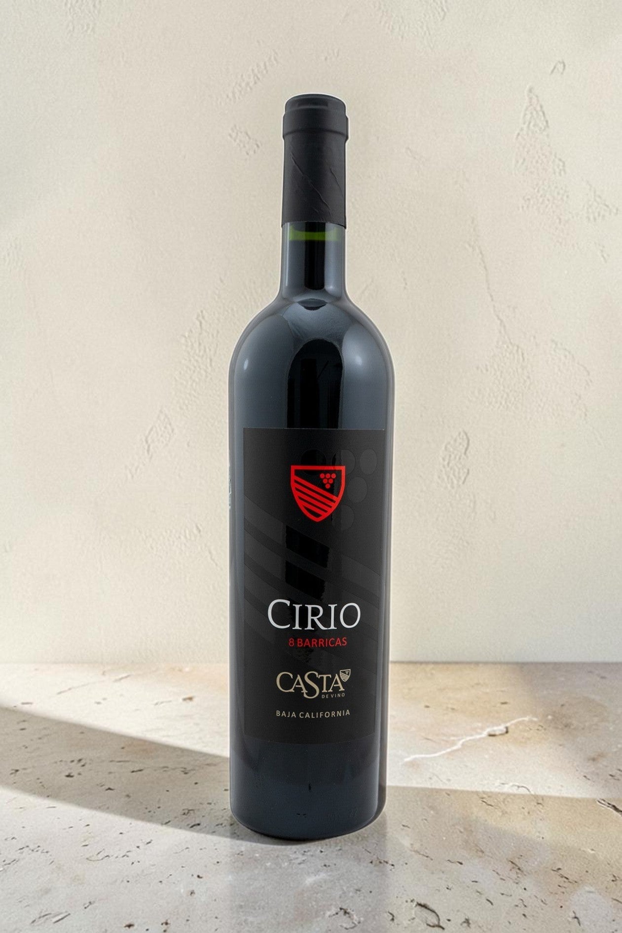 Botella de vino tinto Wellnex Cirio con etiqueta negra y logo rojo sobre fondo claro
