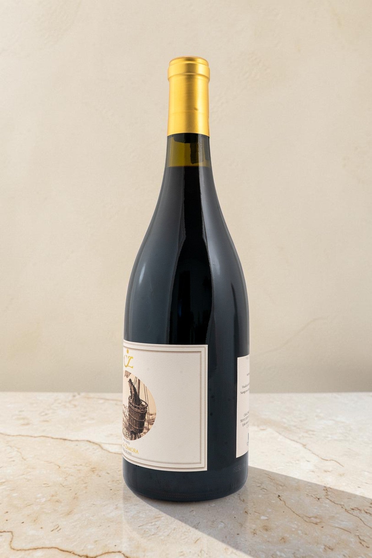 Botella de vino tinto Cofa de Wellnex con etiqueta ilustrada y cápsula dorada sobre superficie de mármol