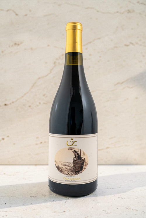 Botella de vino tinto Cofa de Wellnex con etiqueta ilustrada, cápsula dorada y diseño elegante sobre fondo claro.