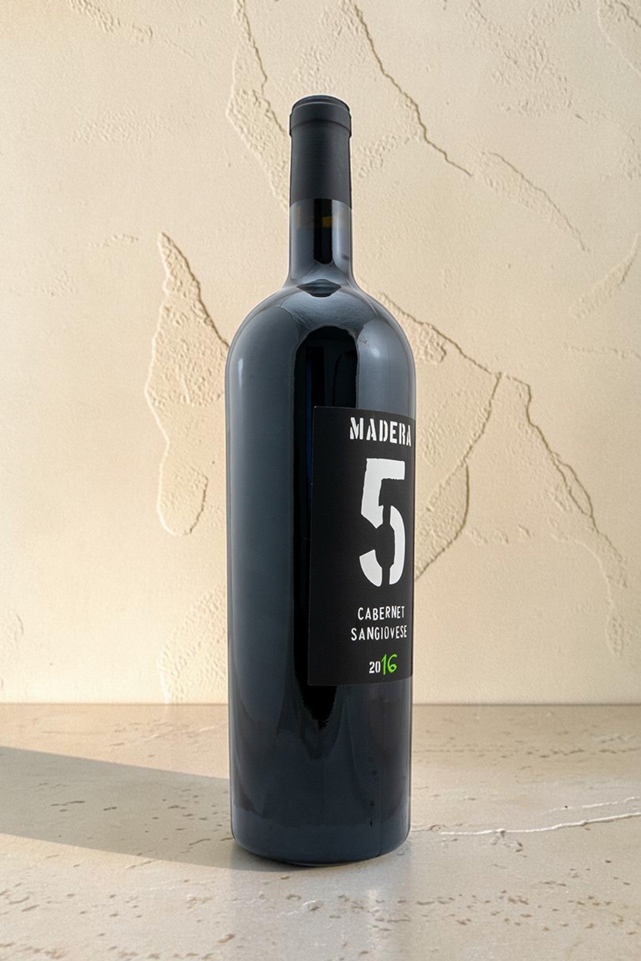 Botella de vino tinto Wellnex Magnum Cabernet Sangiovese 2016 con etiqueta negra y diseño minimalista