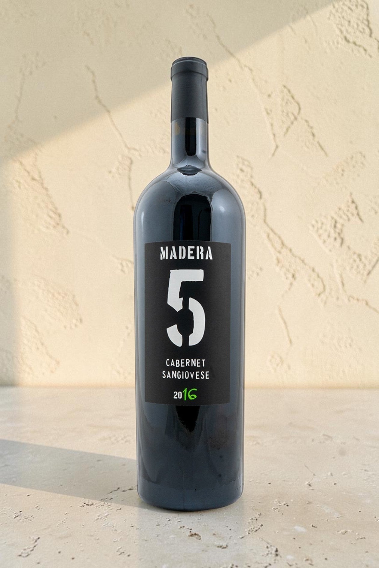 Botella de vino tinto Wellnex Magnum Cabernet Sangiovese 2016 con etiqueta negra y diseño minimalista