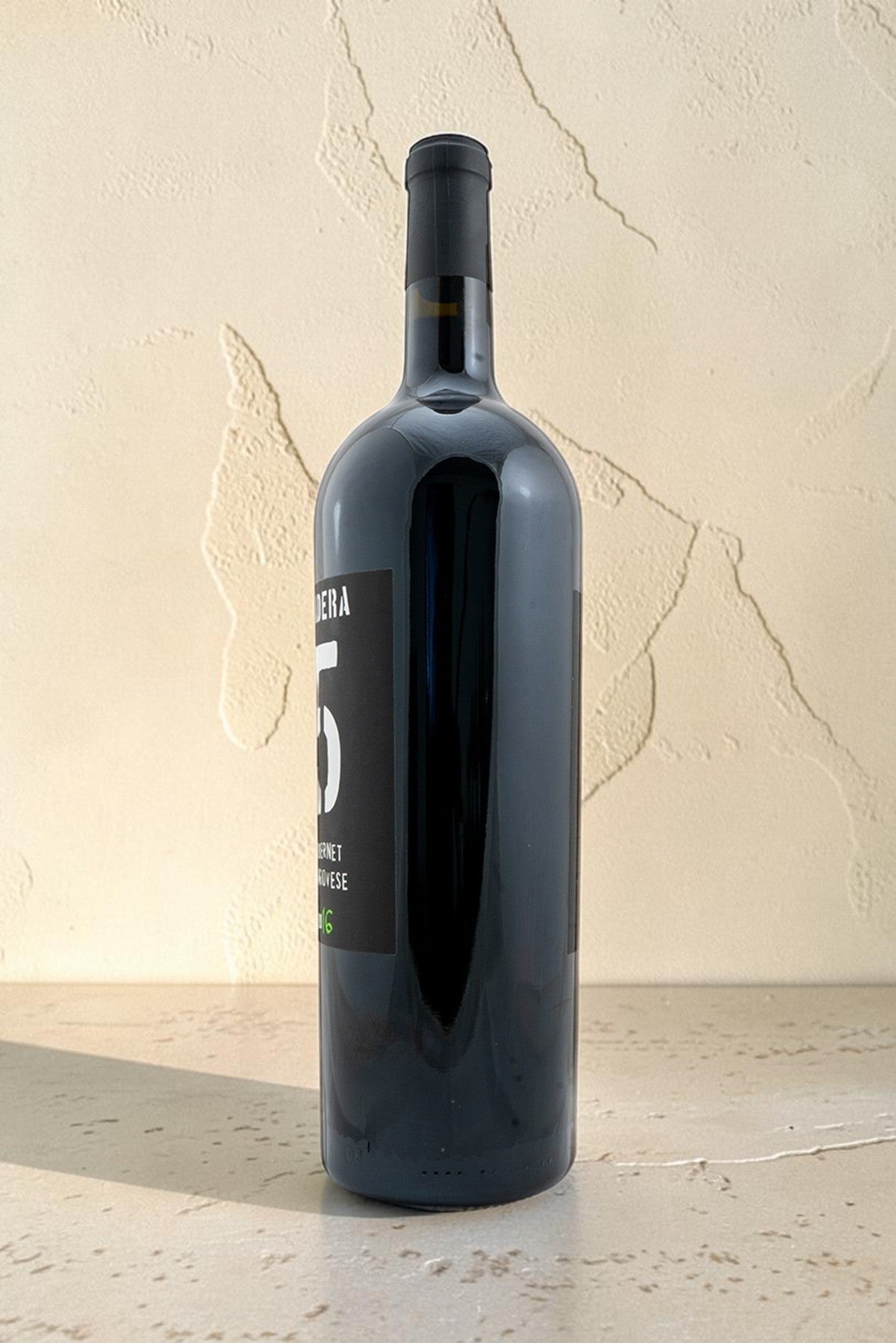 Botella de vino tinto Magnum Cabernet Sangiovese de Wellnex con etiqueta negra y diseño elegante