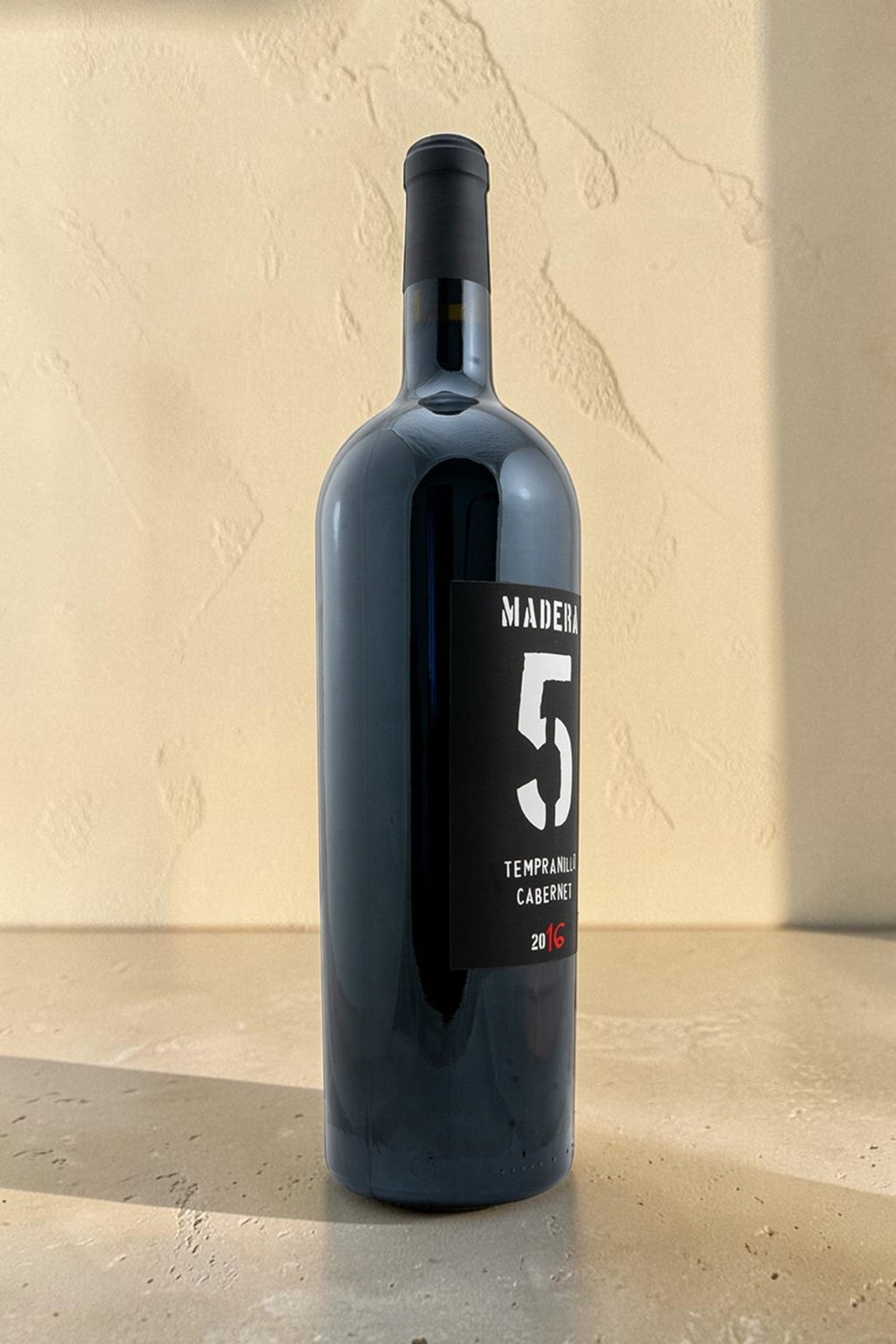 Botella de vino tinto Wellnex Magnum Tempranillo Cabernet 2016 con etiqueta negra y diseño minimalista