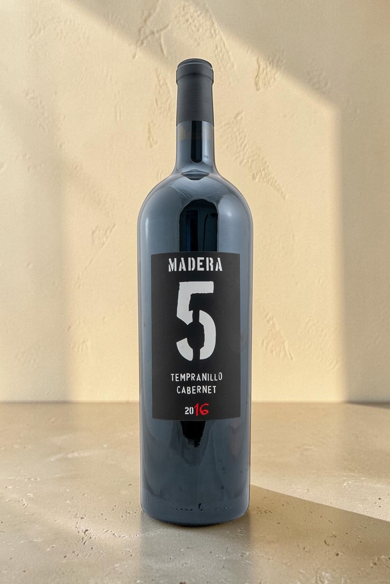 Botella de vino tinto Wellnex Magnum Tempranillo Cabernet 2016 con etiqueta negra y numero cinco grande