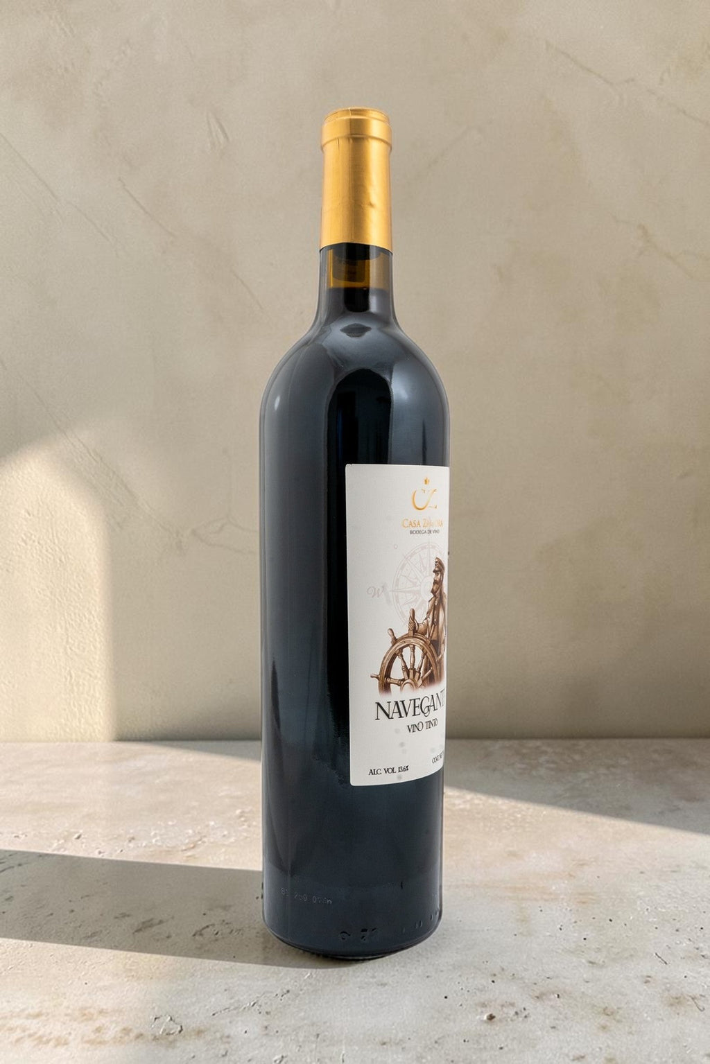 Botella de vino tinto Navegante de Wellnex con etiqueta ilustrada de un timón sobre fondo neutro