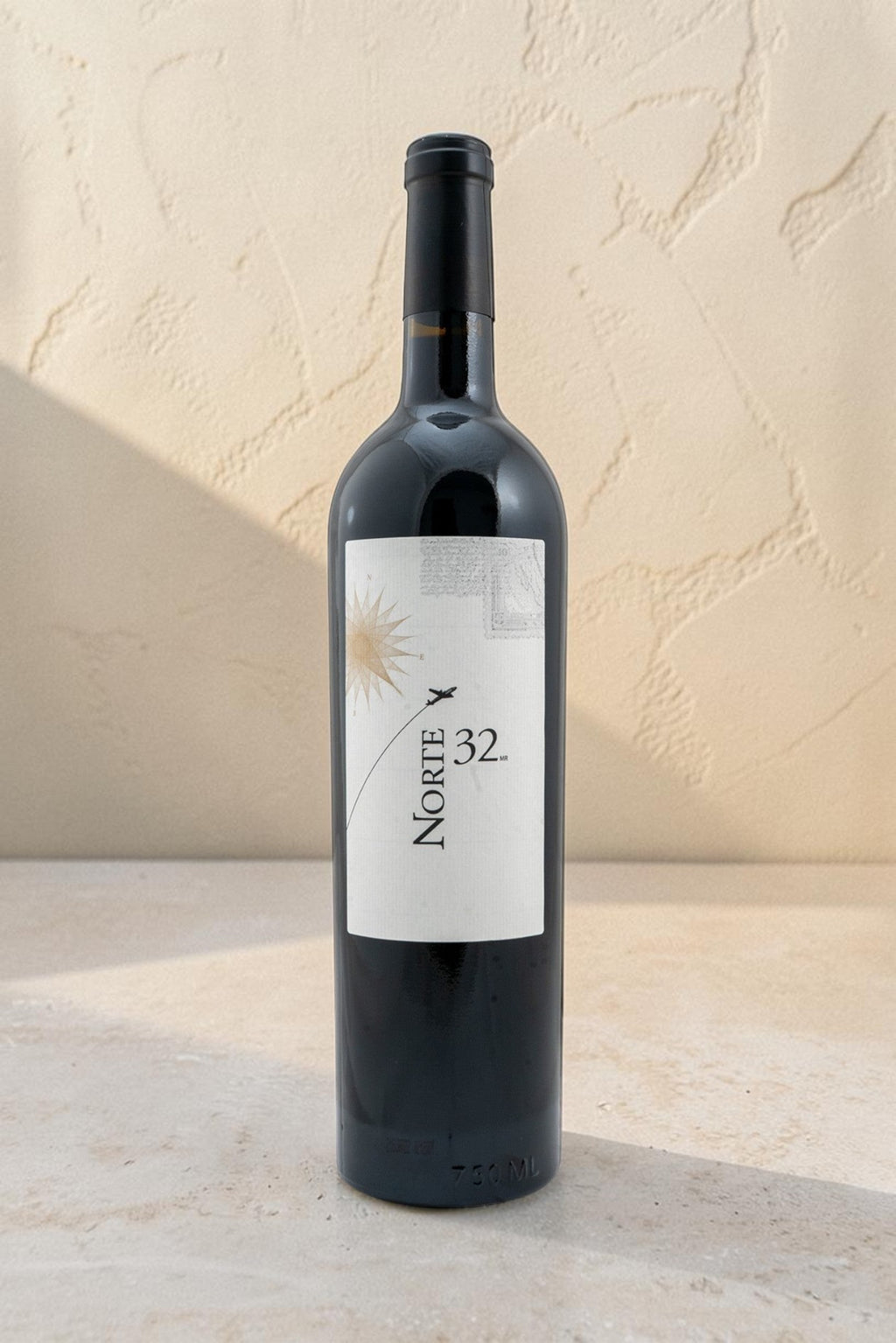 Botella de vino tinto Norte 32 Etiqueta Blanca de Wellnex con diseño elegante sobre fondo neutro