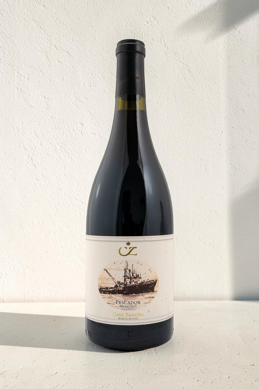 Botella de vino tinto Pescador de Wellnex con etiqueta ilustrada de un barco pesquero sobre fondo blanco