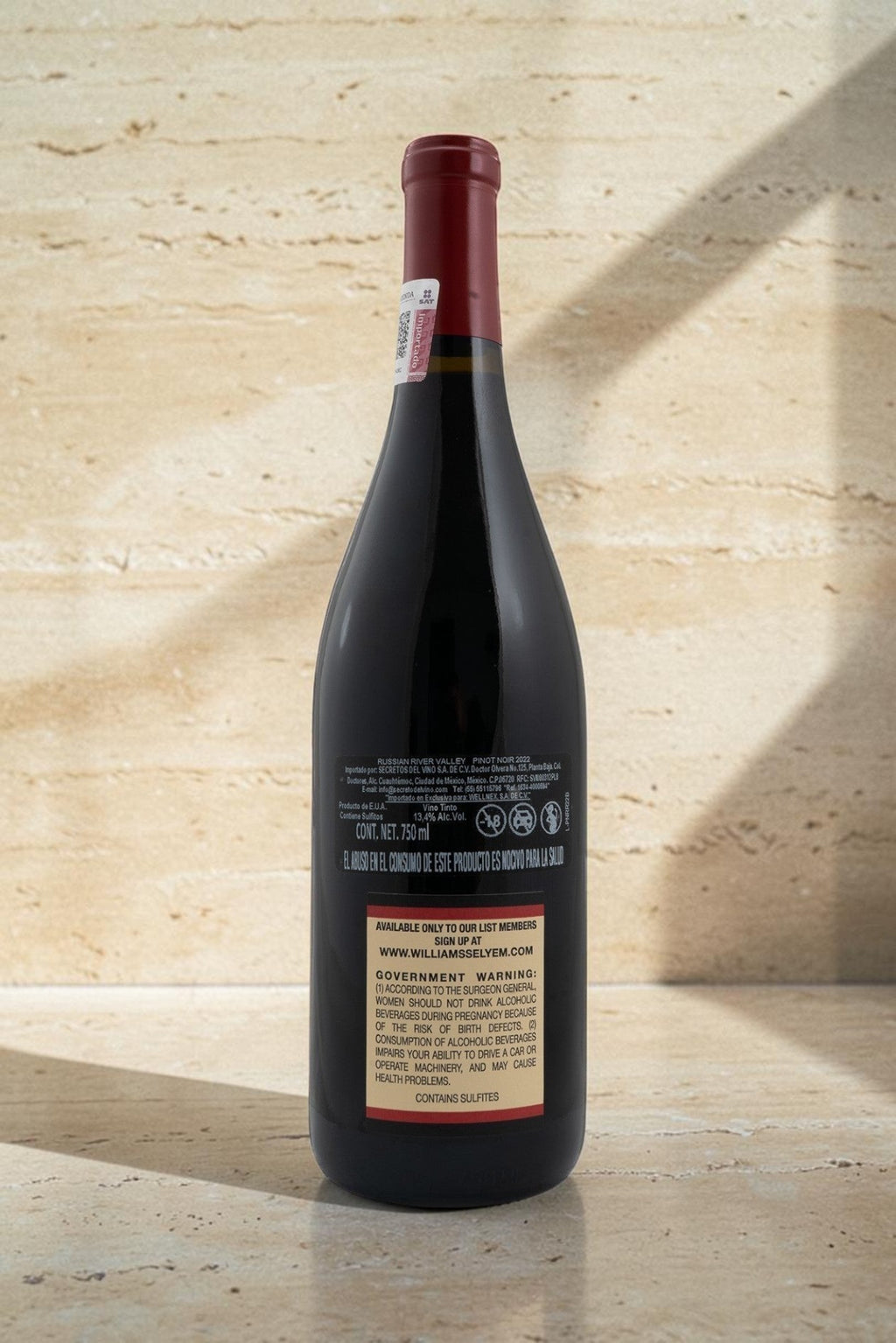 Botella de vino tinto Wellnex Russian River Valley Pinot Noir con etiqueta trasera informativa sobre fondo beige