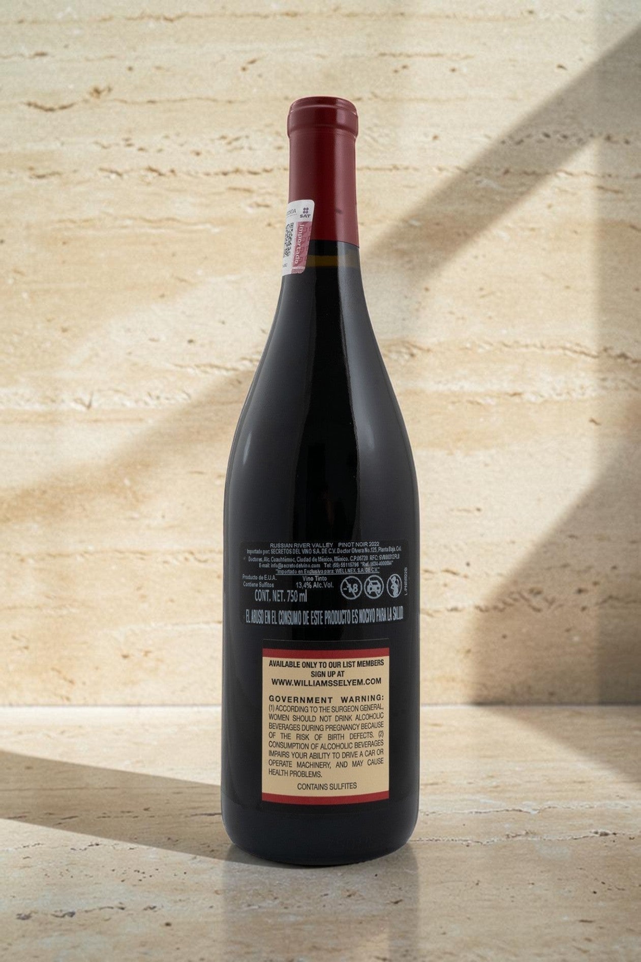 Botella de vino tinto Wellnex Russian River Valley Pinot Noir con etiqueta trasera informativa sobre fondo beige