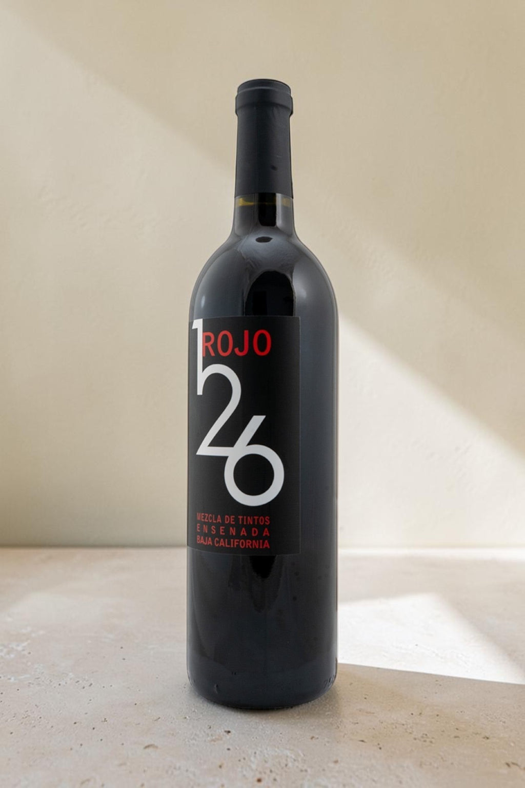 Botella de vino tinto Wellnex Rojo 126 con etiqueta negra moderna sobre fondo neutro