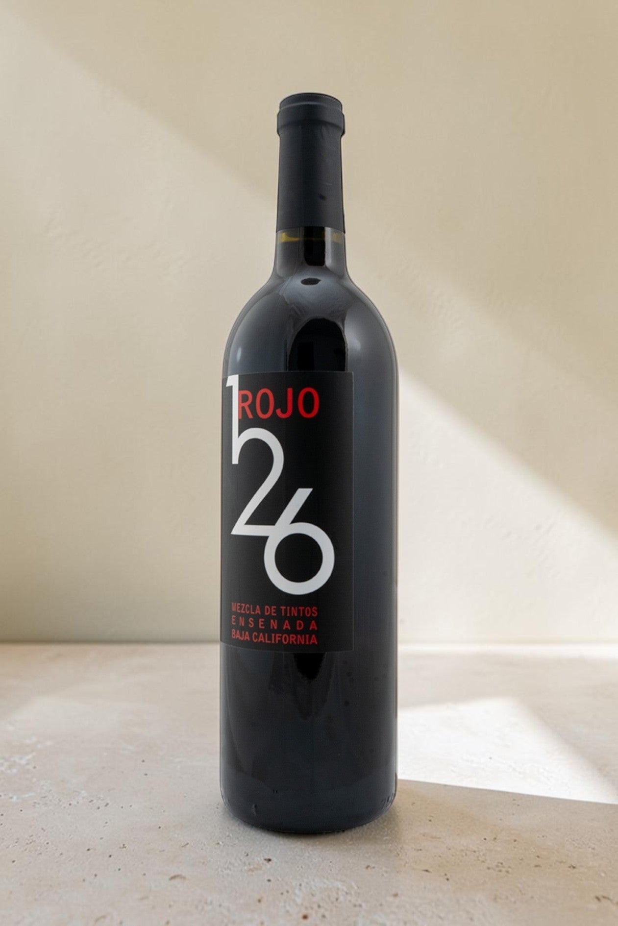 Botella de vino tinto Wellnex Rojo 126 con etiqueta negra moderna sobre fondo neutro
